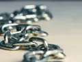 Metalowe szekle tworzą łańcuch, który może symbolizować siłę lub ograniczenia.
