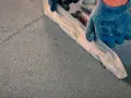 Rękawica w niebieskiej rękawicy wygładza świeży **miksokret** za pomocą kielni.