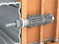 Przekrój przez cegłę pokazuje, jak kotwy chemiczne mocują profil aluminiowy.