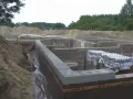 Fundament domu z bloczków betonowych, z widoczną izolacją i przygotowaniem pod keramzytobeton. Budowa w toku.