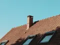 Ceglany dach z kominem i oknami dachowymi, gotowy do mycia.