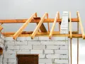 Drewniana więźba dachowa na budowie domu z bloczków betonowych. Sprawdź, jaka jest aktualna więźba dachowa cena.