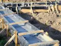 Budowa fundamentów: betonowe ławy w drewnianym szalunku, wyłożone czarną folią.