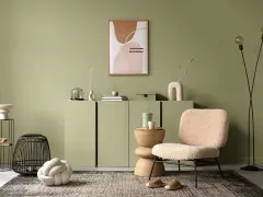 Przytulny salon w odcieniu **kolor sage**. Miękkie fotele, dekoracje i sztuka tworzą relaksującą atmosferę.