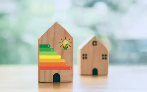 Drewniane domki z etykietą **klasa energetyczna** A-G i symbolem żarówki.