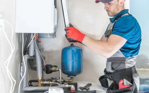Instalator sprawdza podzespoły kotła gazowego. Zastanawiasz się, ile kosztuje piec gazowy?