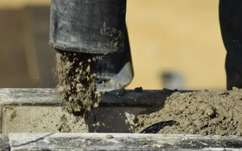 Beton wylewany z rury, rozpoczyna się proces jego wiązania. Czas, ile schnie beton, zależy od wielu czynników.