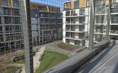 Nowoczesne bloki mieszkalne z balkonami, zabezpieczone siatką. Zastanawiasz się, ile kosztuje montaż siatki na balkonie?