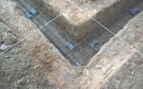 Zbrojenie fundamentów w wykopie. Różne rodzaje betonu zostaną tu wkrótce wylane, tworząc solidną podstawę.