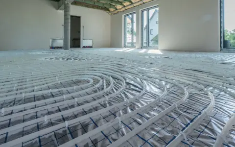 Instalacja ogrzewania podłogowego w nowym domu. Rozłożone rury zapowiadają komfort i niższy koszt ogrzewania.
