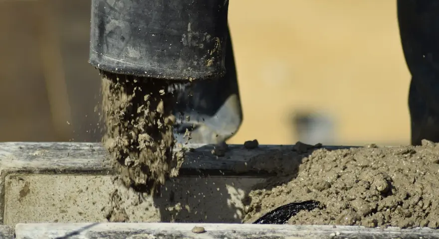 Beton wylewany z rury, rozpoczyna się proces jego wiązania. Czas, ile schnie beton, zależy od wielu czynników.