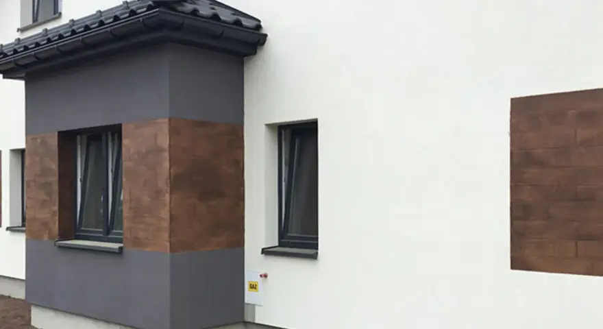 Nowoczesna elewacja z elementami imitującymi drewno, wykonana z tynków cementowo wapiennych.