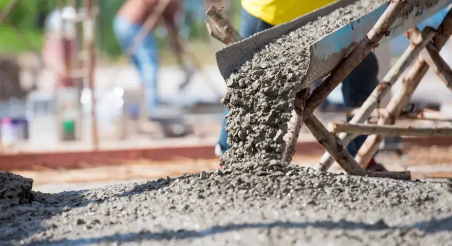 Beton wylewany z betoniarki. Pracownicy na budowie, zastanawiają się, ile cementu na kubik betonu potrzeba do wykonania solidnej konstrukcji.