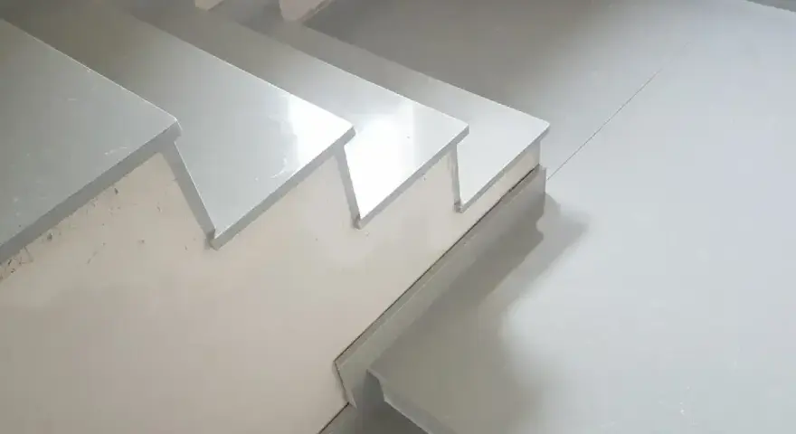 Nowoczesne schody z aglomarmuru w jasnym kolorze, idealne do minimalistycznych wnętrz.