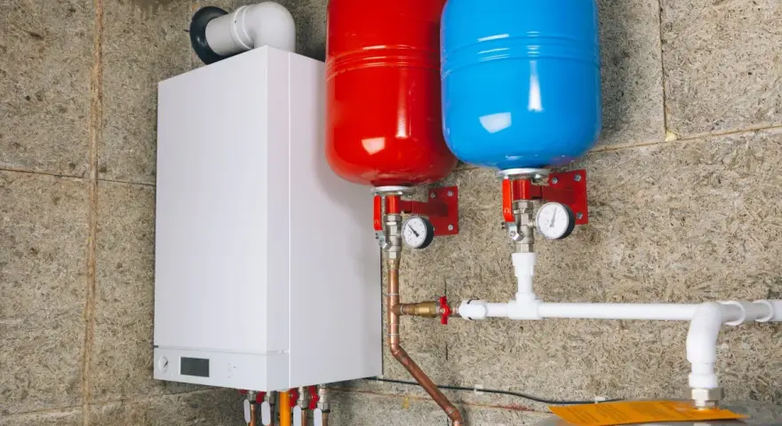 Nowoczesny kocioł gazowy z dwoma zbiornikami przeponowymi (czerwonym i niebieskim) oraz instalacją hydrauliczną.
