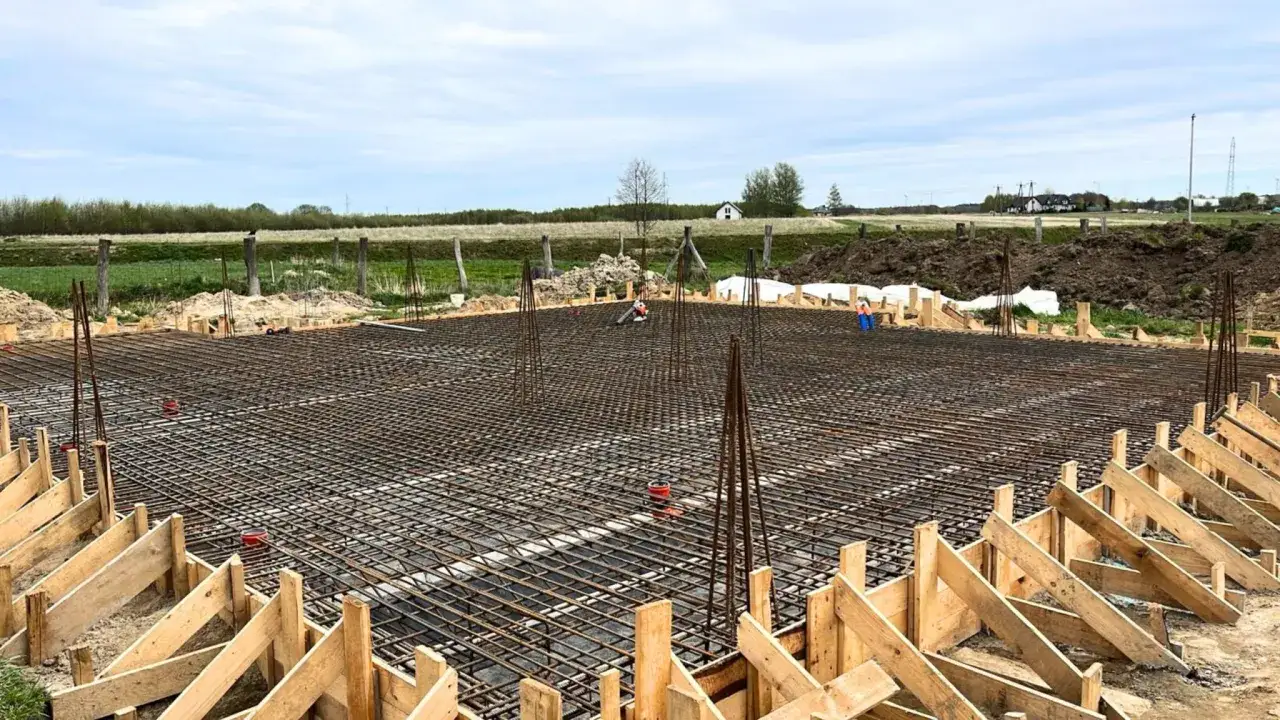 Fundamenty domu w budowie. Siatka zbrojeniowa i szalunki czekają na beton. To pierwszy etap, od którego zależy, ile trwa budowa domu.