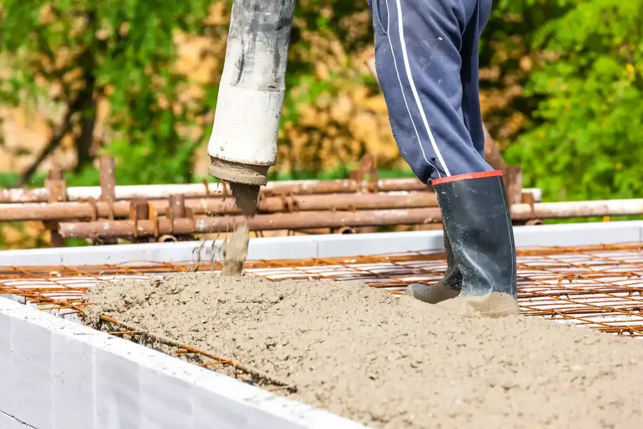 Betoniarka wylewa beton na zbrojenie. Zastanawiasz się, ile kosztuje kubik betonu?